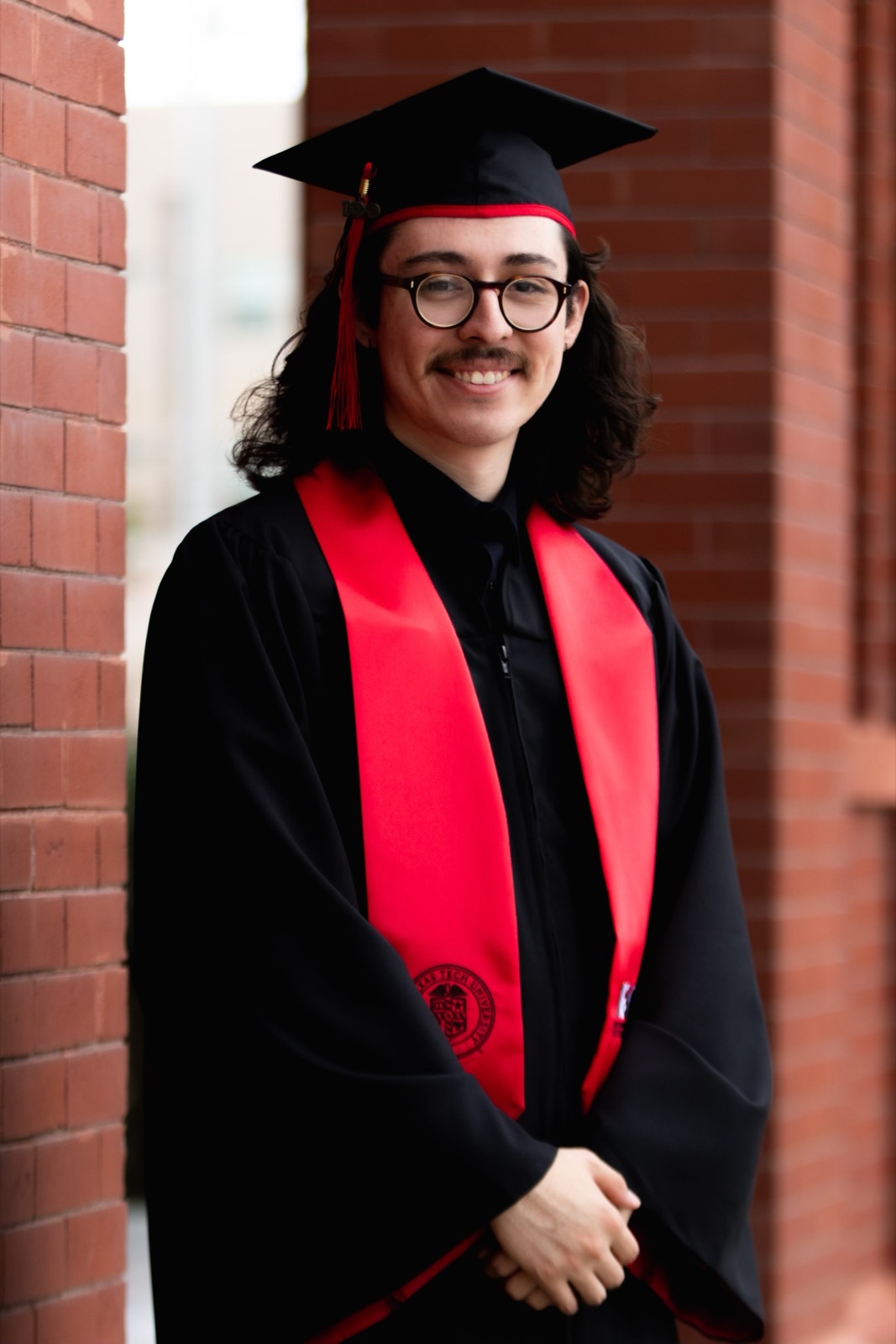 A graduate in a cap and red stole