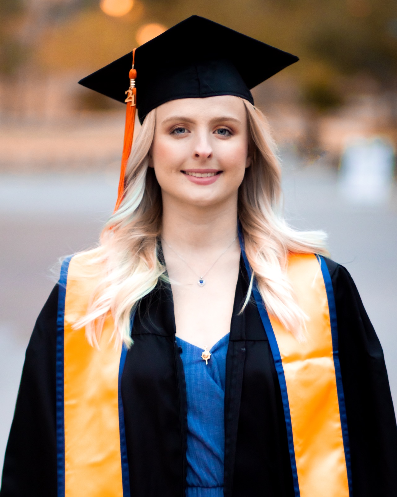 A graduate in a cap and gown outdoors