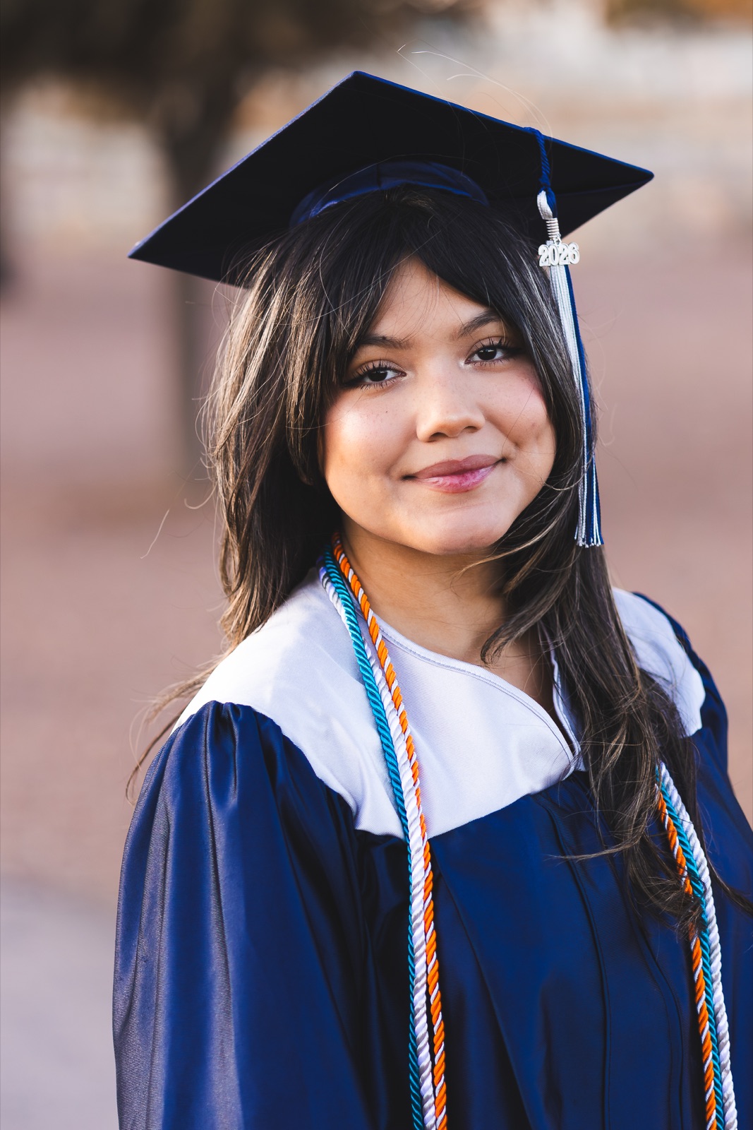 A graduate smiling in a cap and gown