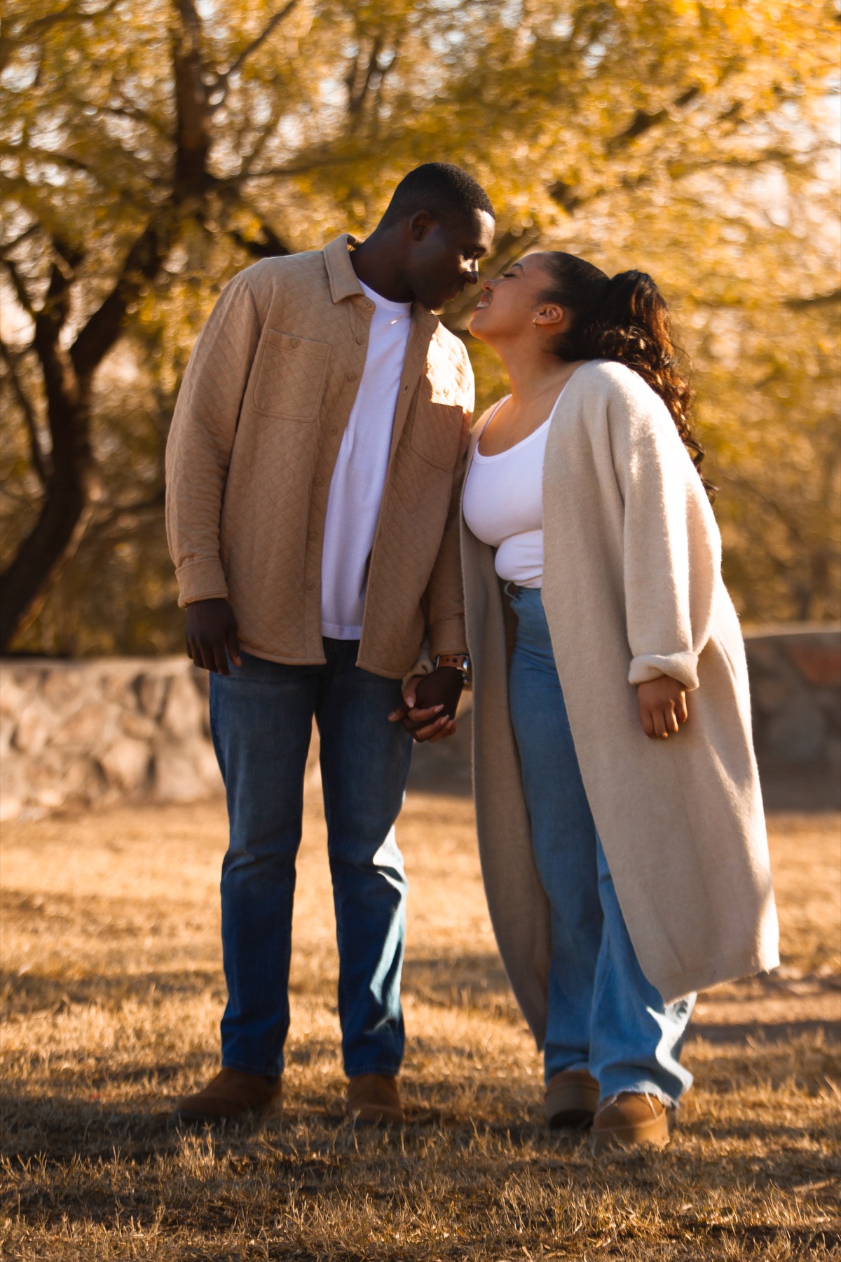 Ayo kissing Jordin’s forehead beneath golden trees